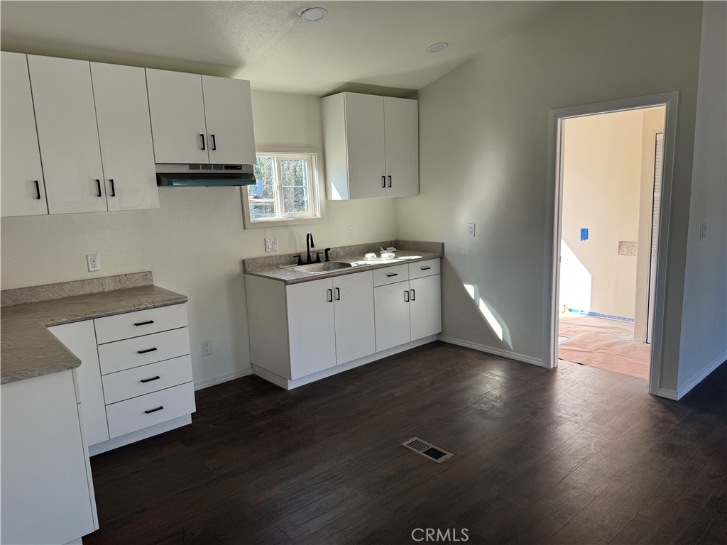 28110 Winchester Road Winchester, CA 92596 - Photo 39 of 40 a kitchen with granite countertop a stove cabinets and wooden floor