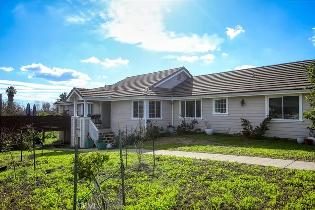 a front view of a house with a garden and plants