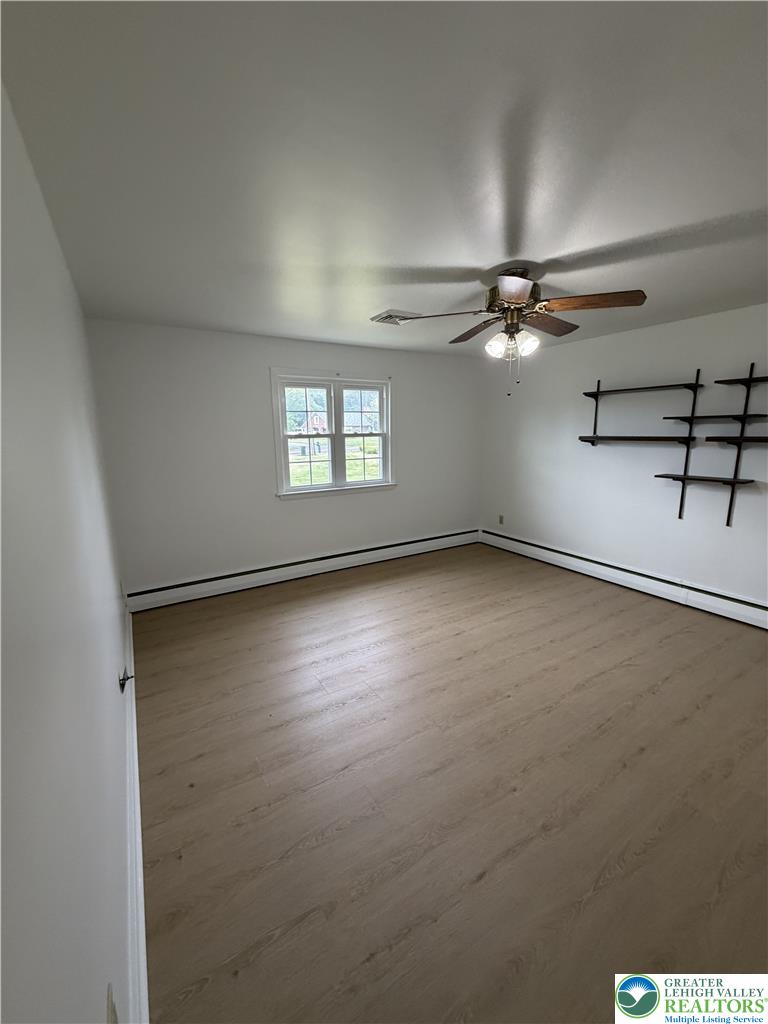 5391 Chapmans Road, Unit 2 Orefield, PA 18069 - Photo 16 of 22 A well-lit bedroom features durable laminate flooring and a ceiling fan for comfort.