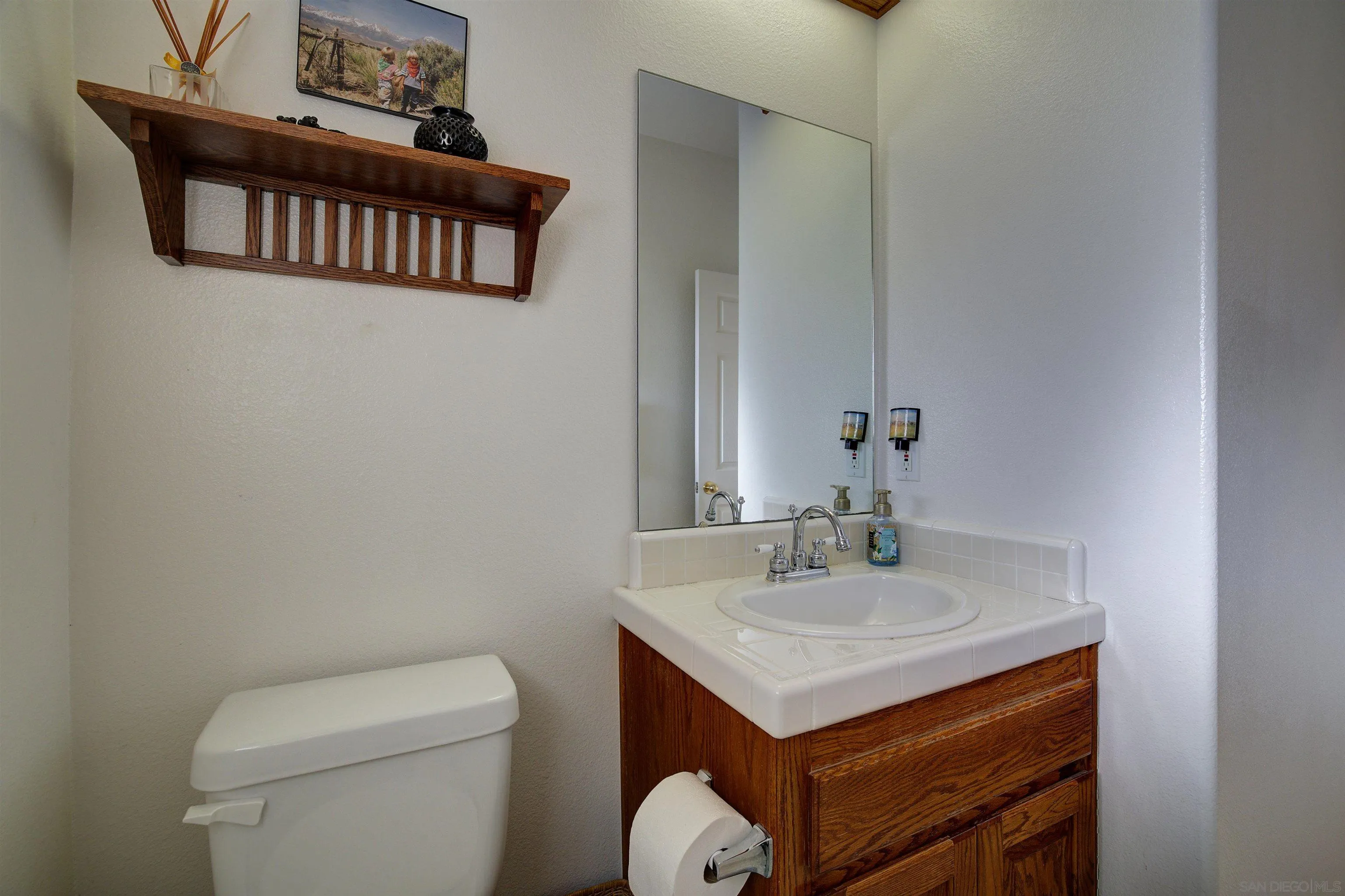 30578 Roadrunner Ridge Valley Center, CA 92082 - Photo 25 of 29 a bathroom with a sink a toilet and a mirror