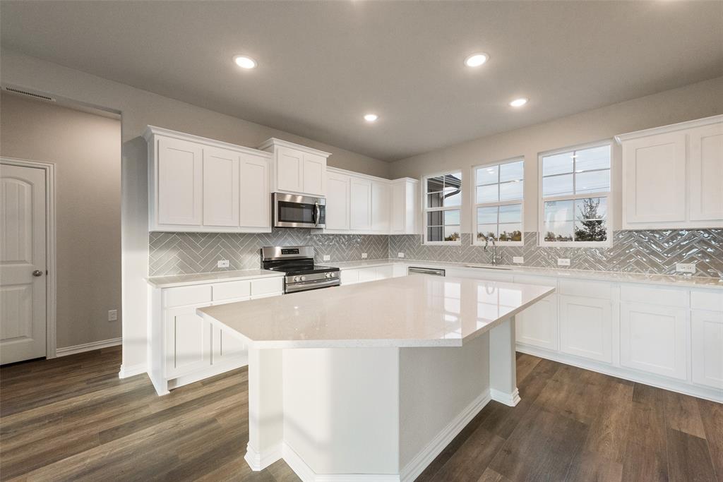 1230 County Road 200 Valley View, TX 76272 - Photo 12 of 26 Kitchen featuring stainless steel appliances, white cabinetry, light stone countertops, dark wood-style floors, and a center island