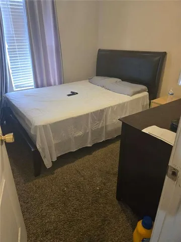 a bed sitting in a bedroom next to a window