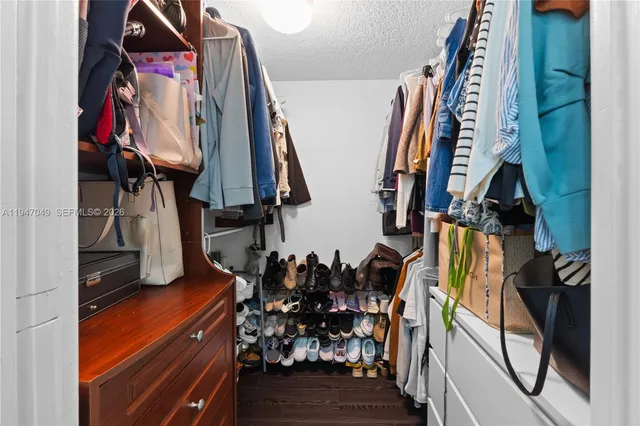 a view of walk in closet with clothes and shoes