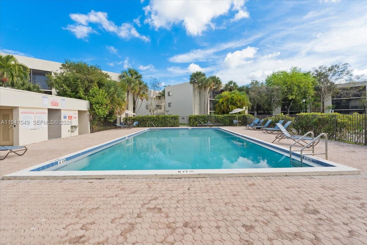 8075 Southwest 107th Avenue, Unit 221 Miami, FL 33173 - Photo 20 of 26 a view of a swimming pool and trees in the background