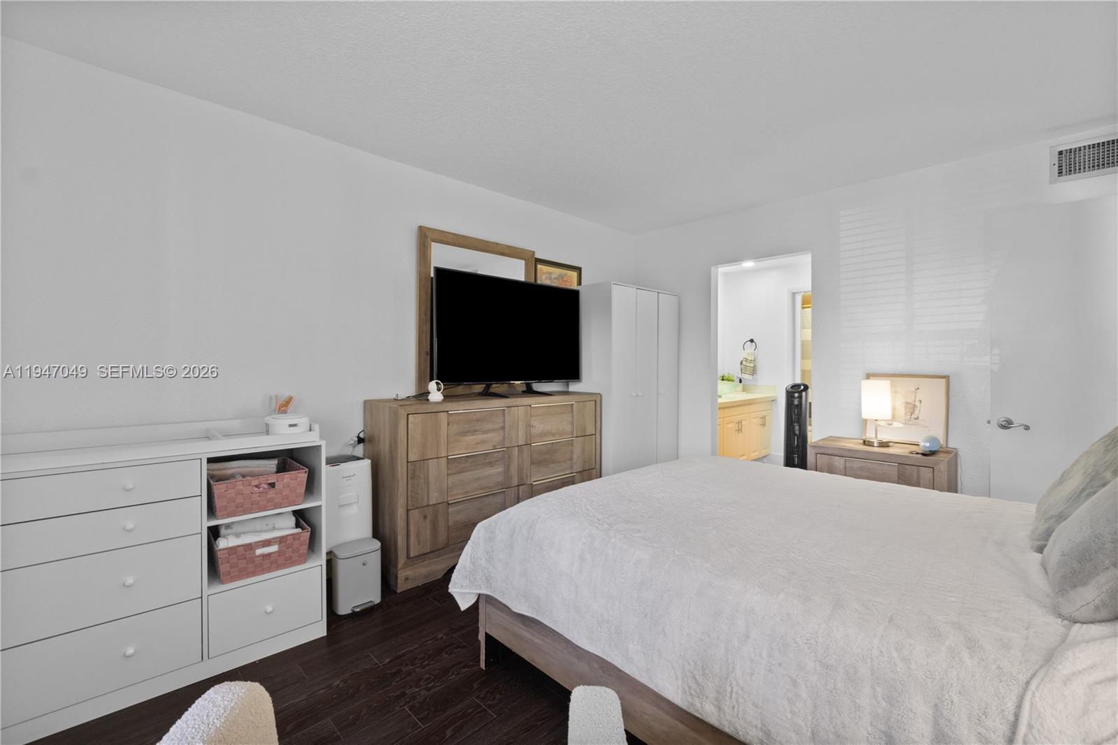 8075 Southwest 107th Avenue, Unit 221 Miami, FL 33173 - Photo 4 of 26 a bedroom with a bed and flat tv screen on the dresser