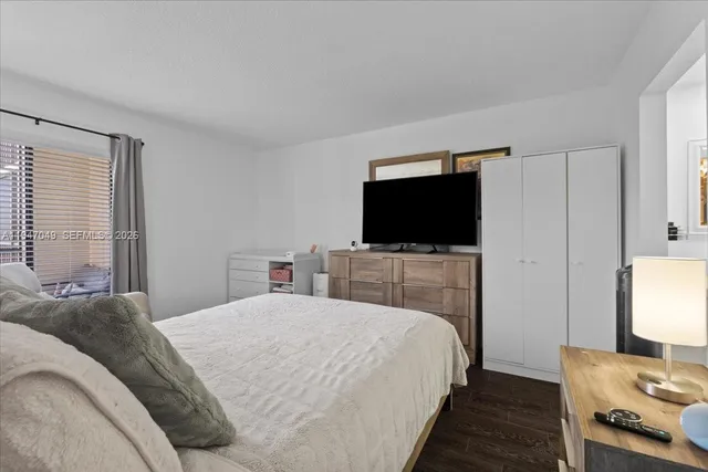 a bedroom with a bed and a flat screen tv