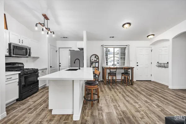 a kitchen with stainless steel appliances granite countertop a sink stove and refrigerator