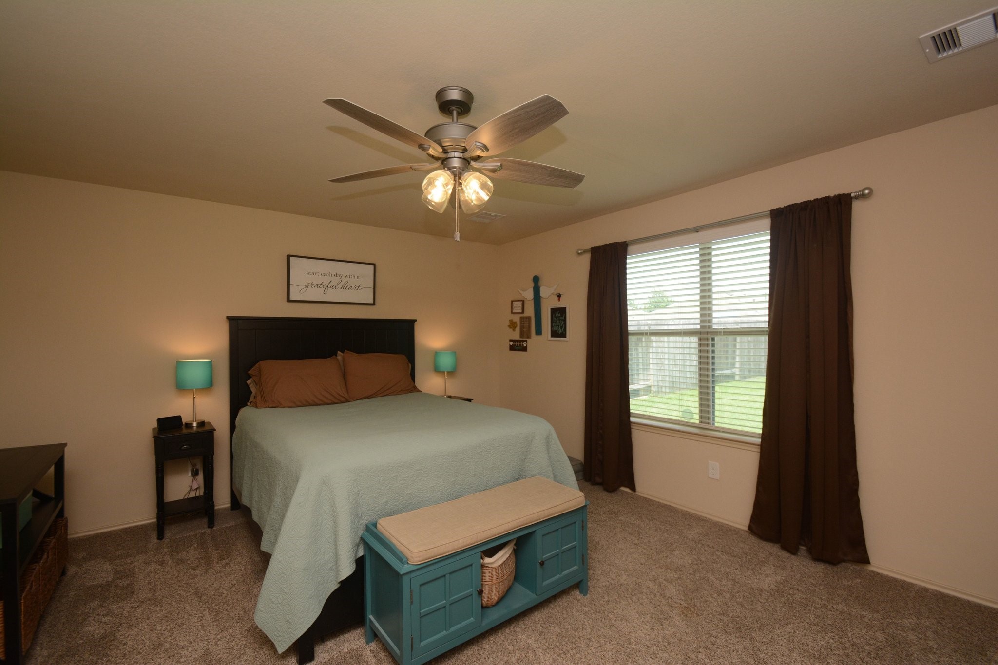 23318 Dukes Run Drive Spring, TX 77373 - Photo 25 of 41 This cozy bedroom features a neutral color palette with a large window providing natural light. It includes a ceiling fan and carpeted flooring.