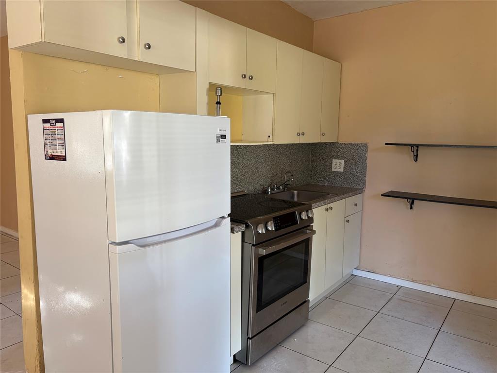 45 Northeast 146th Street, Unit B Miami, FL 33161 - Photo 5 of 16 a white refrigerator freezer and a stove sitting inside of a kitchen