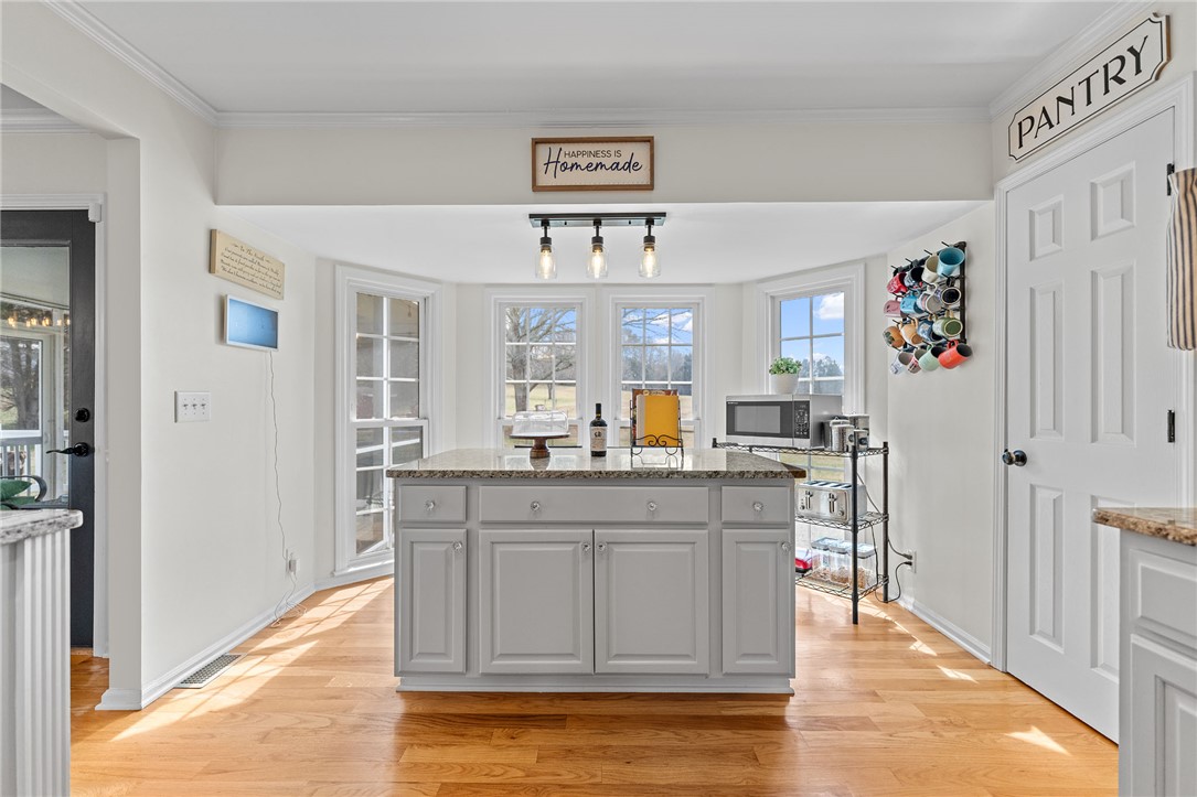 200 Poore Road Piedmont, SC 29673 - Photo 15 of 44 This spacious kitchen features a central island, ample natural light, and classic hardwood flooring.