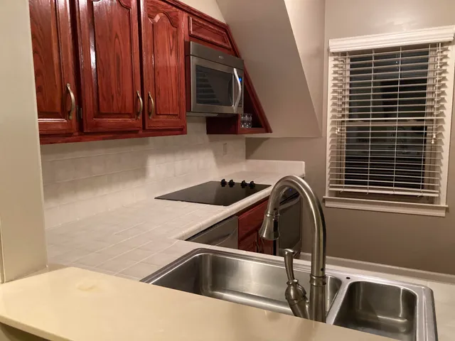 a kitchen with a sink cabinets and a window