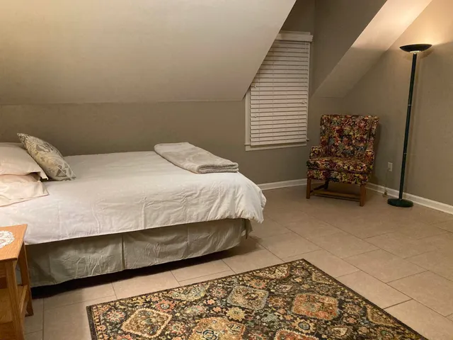 a bedroom with a bed and a chair