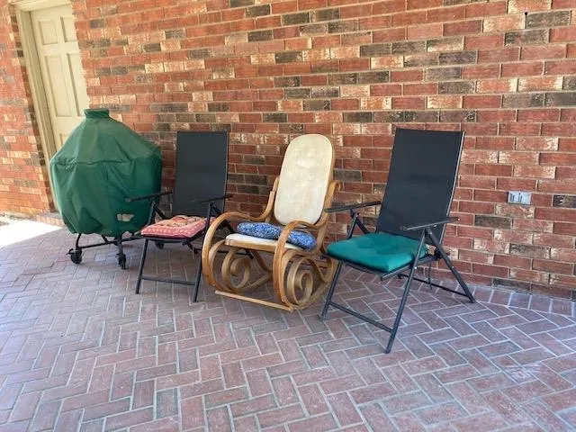 a couple of chairs sitting in backyard of a building