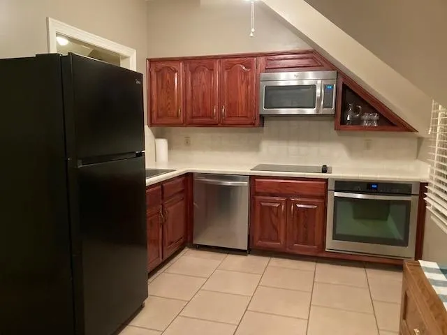 a kitchen with stainless steel appliances granite countertop a refrigerator and a stove top oven