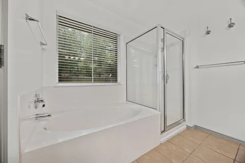 a white bath tub sitting next to a shower