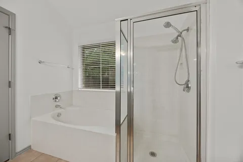 a bathroom with a shower and a bath tub