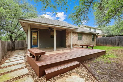 a view of a patio with table and chairs with wooden fence and floor