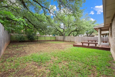 a view of a backyard with table and chairs and a large tree