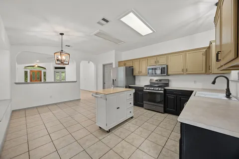 a kitchen with stainless steel appliances granite countertop a stove a sink and a refrigerator