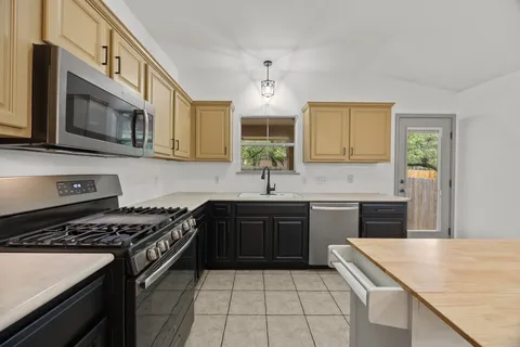 a kitchen with a sink stove top oven and cabinets