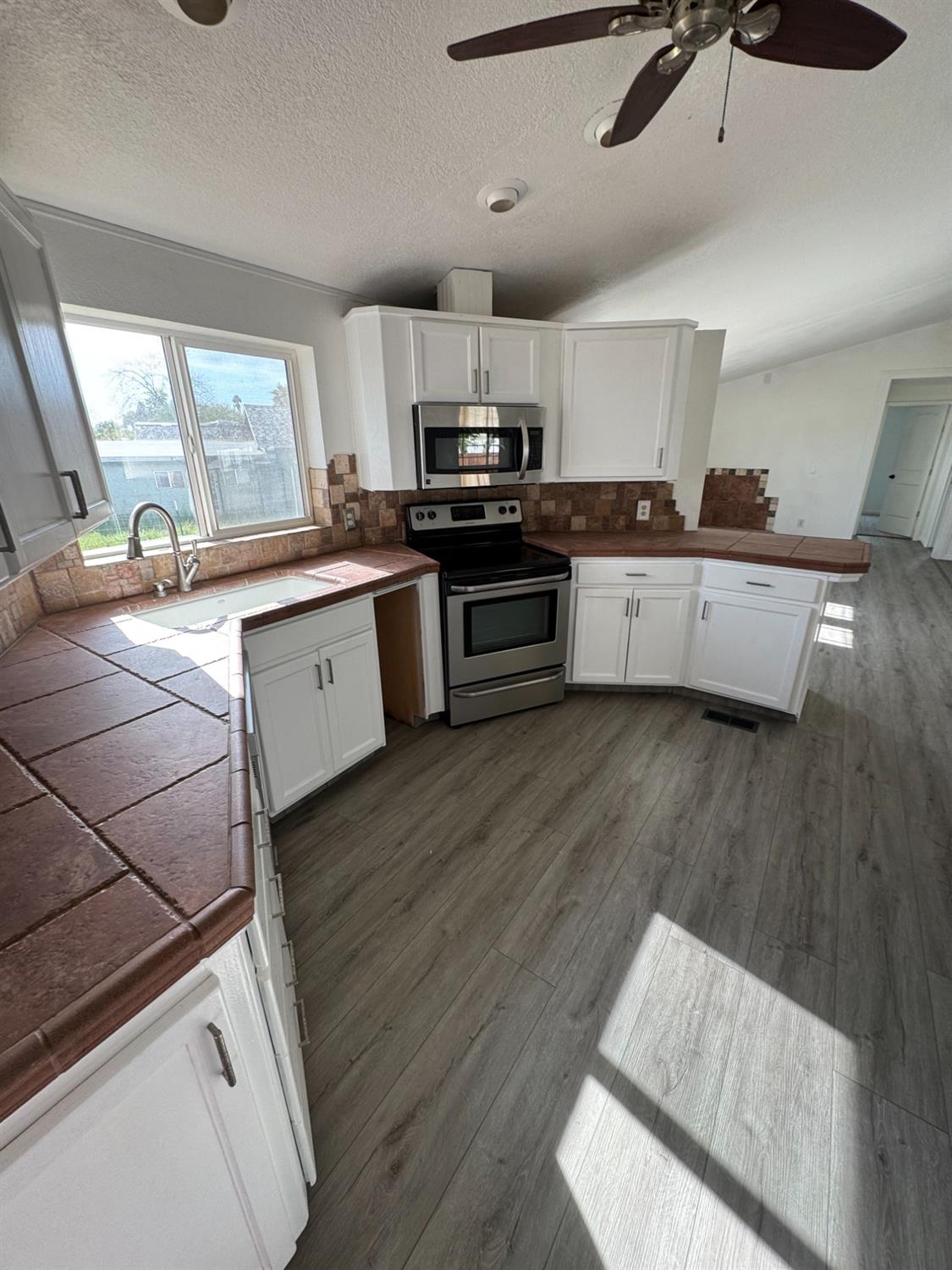 28640 Ward Street Madera, CA 93638 - Photo 11 of 31 a kitchen with granite countertop a stove a sink and a refrigerator