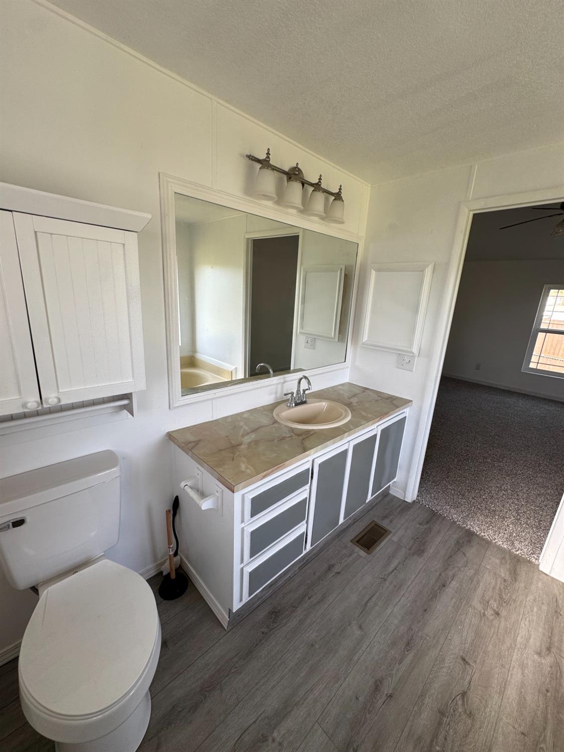 28640 Ward Street Madera, CA 93638 - Photo 23 of 31 a bathroom with a sink a toilet and mirror