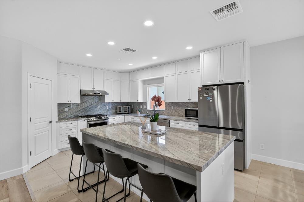 7605 Ferrell Way Elk Grove, CA 95757 - Photo 17 of 69 a kitchen with stainless steel appliances granite countertop a kitchen island a stove a table and chairs