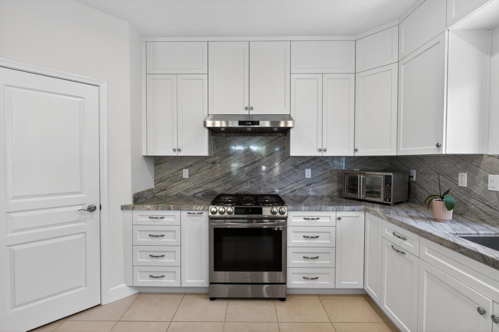 7605 Ferrell Way Elk Grove, CA 95757 - Photo 19 of 69 a kitchen with granite countertop white cabinets and stainless steel appliances
