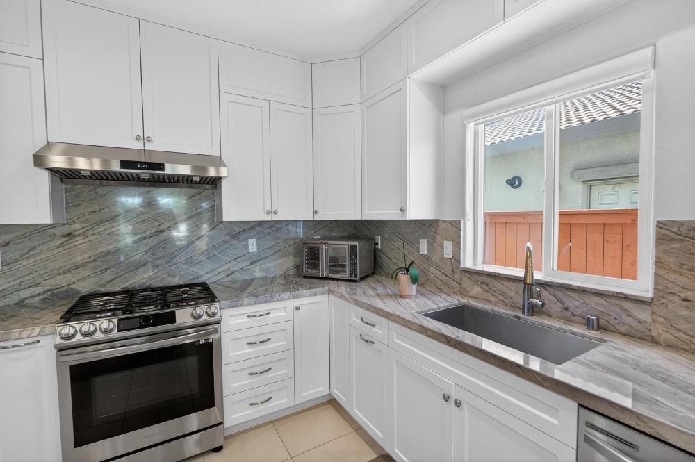 7605 Ferrell Way Elk Grove, CA 95757 - Photo 20 of 69 a kitchen with granite countertop white cabinets and a stove
