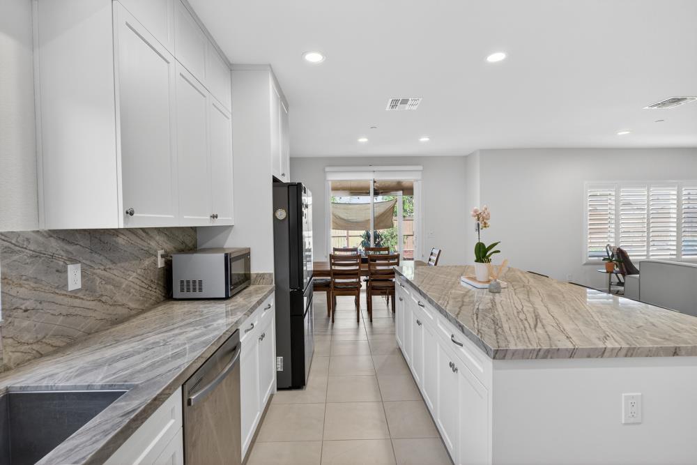 7605 Ferrell Way Elk Grove, CA 95757 - Photo 21 of 69 a large kitchen with granite countertop a large counter top and stainless steel appliances
