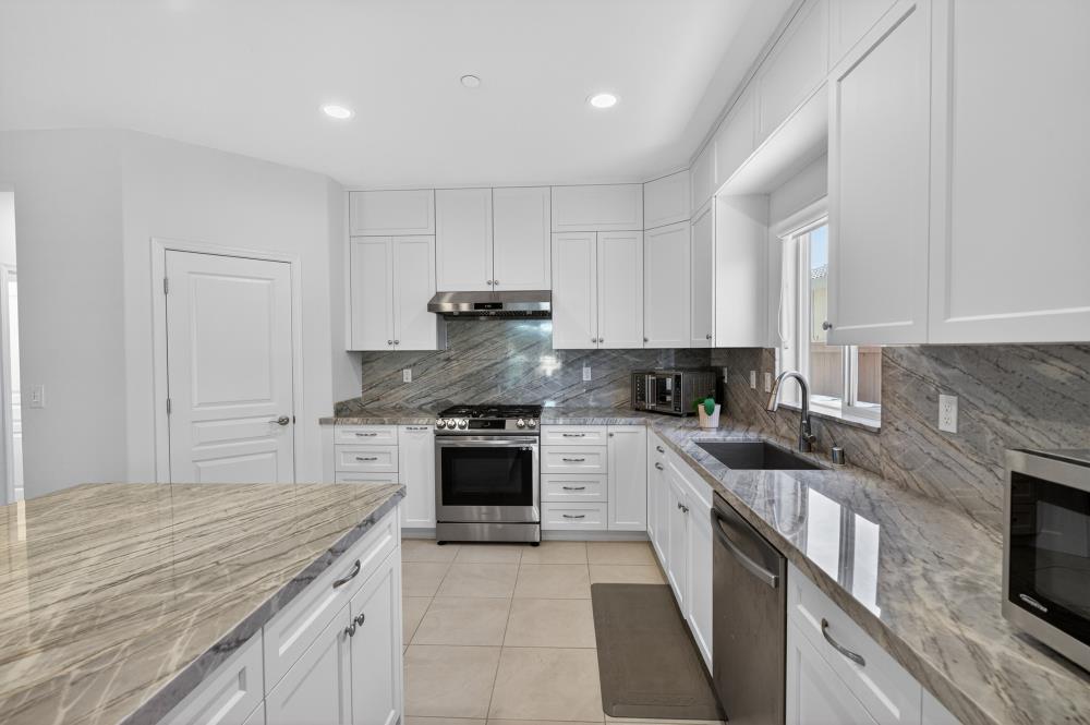 7605 Ferrell Way Elk Grove, CA 95757 - Photo 24 of 69 a kitchen with kitchen island granite countertop a stove sink and cabinets