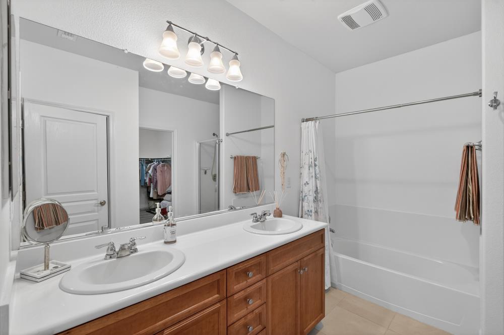7605 Ferrell Way Elk Grove, CA 95757 - Photo 35 of 69 a bathroom with a granite countertop sink a mirror a shower and a mirror