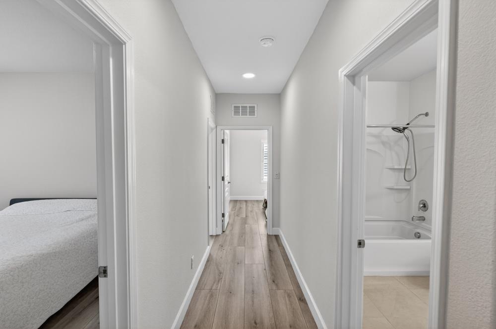 7605 Ferrell Way Elk Grove, CA 95757 - Photo 39 of 69 a view of a hallway with wooden floor and a bathroom