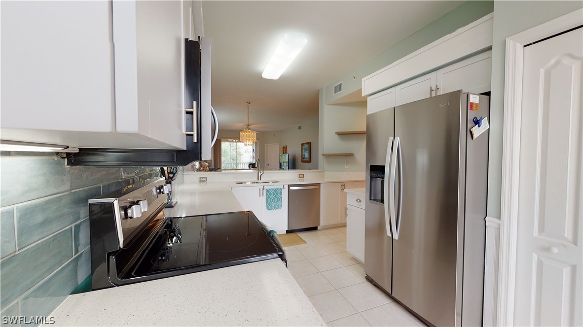 14111 Brant Point Circle, Unit 2201 Fort Myers, FL 33919 - Photo 7 of 30 a kitchen with a sink a refrigerator and cabinets