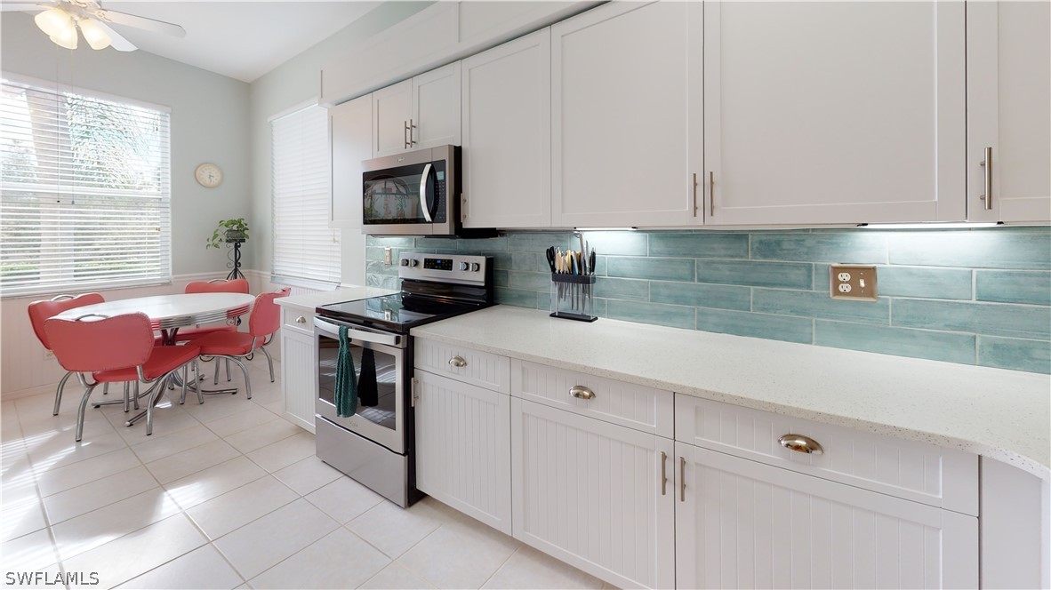 14111 Brant Point Circle, Unit 2201 Fort Myers, FL 33919 - Photo 9 of 30 a kitchen with stainless steel appliances white cabinets and a stove top oven