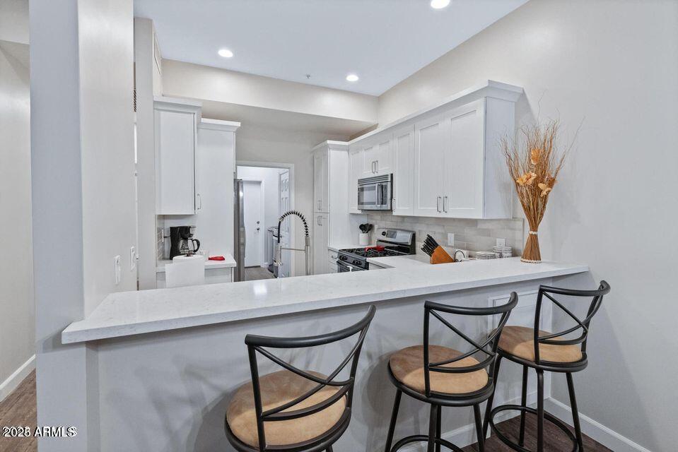 8270 North Hayden Road, Unit 1028 Scottsdale, AZ 85258 - Photo 3 of 22 a kitchen with stainless steel appliances a sink and a refrigerator