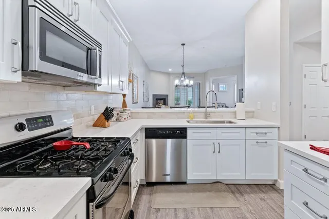 a kitchen with stainless steel appliances a sink stove and cabinets