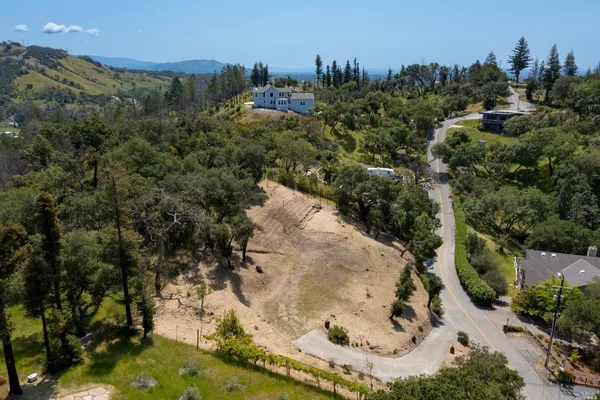 an aerial view of residential house with outdoor space and trees all around