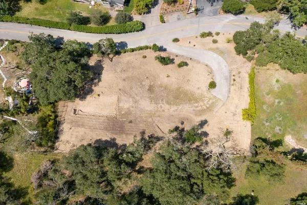 an aerial view of a houses with trees all around