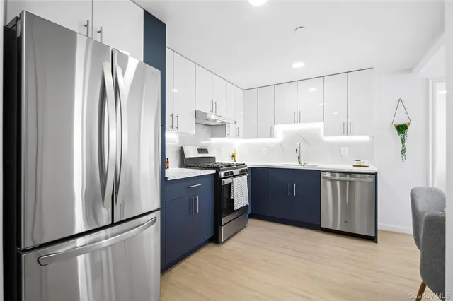 a kitchen with stainless steel appliances granite countertop a refrigerator a sink and dishwasher