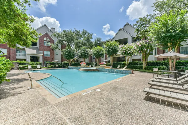 a view of a house with a big yard plants and large trees
