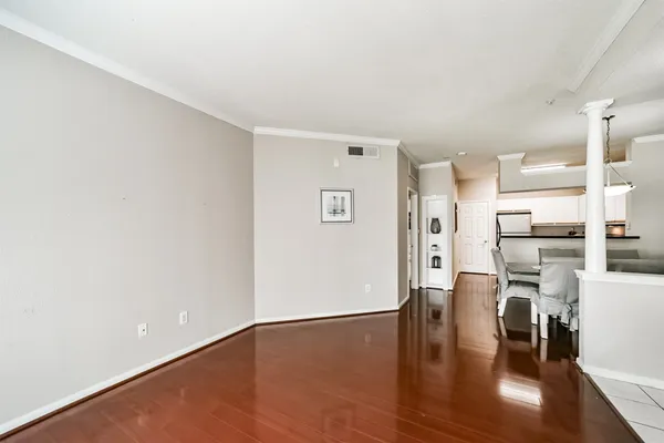 a view of an empty room with window and wooden floor