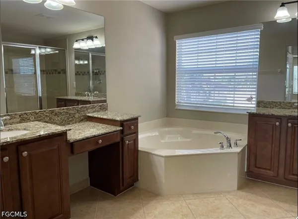 a bathroom with a tub sink and mirror