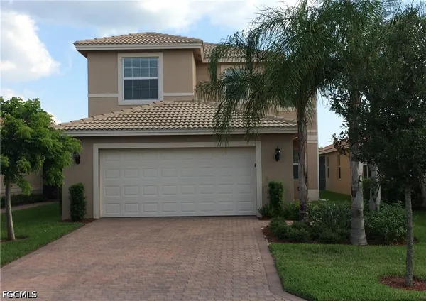 a front view of a house with a garden and garage