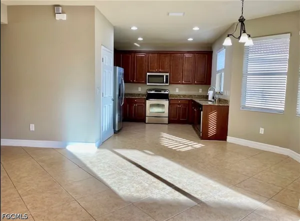 a kitchen with stainless steel appliances granite countertop a sink refrigerator and cabinets