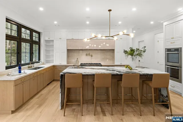 a large kitchen with granite countertop a sink and a stove top oven