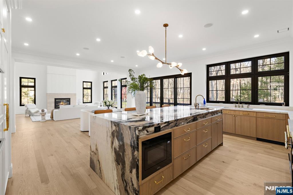 16 Old Farms Road Saddle River, NJ 07458 - Photo 8 of 31 a large kitchen with stainless steel appliances a stove a sink a oven and a large island with wooden floor