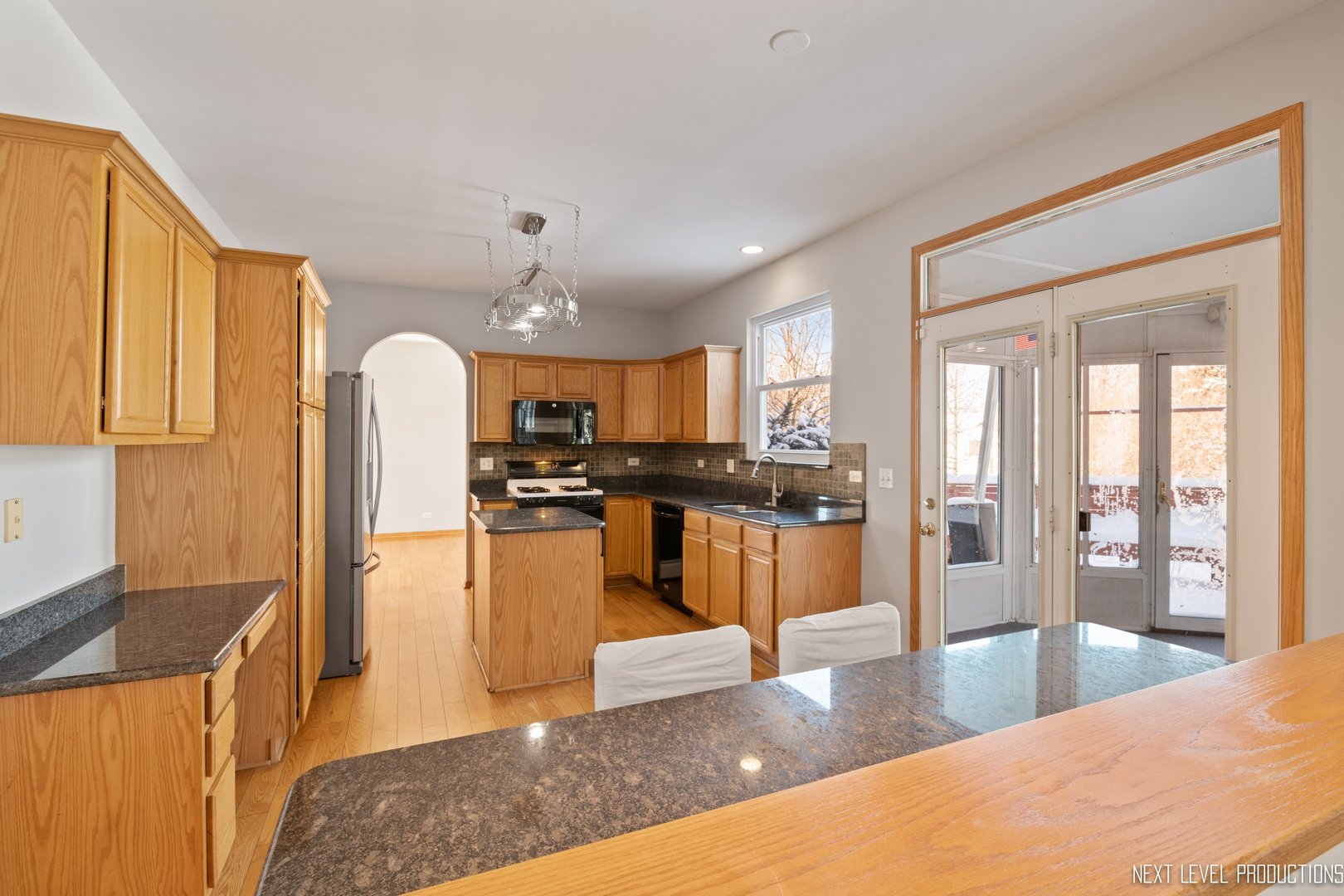 1772 Pinnacle Drive Aurora, IL 60502 - Photo 13 of 48 a kitchen with stainless steel appliances kitchen island granite countertop a refrigerator a stove and a sink with wooden floor