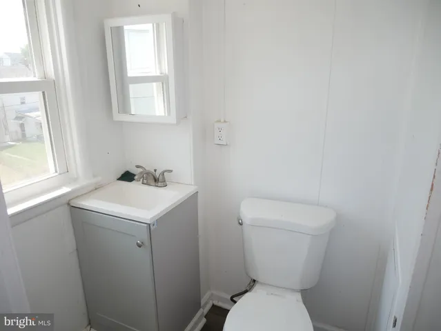 a bathroom with a sink toilet and window