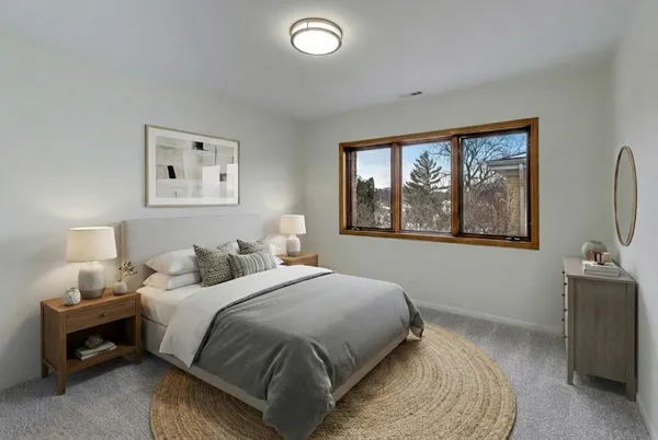 a bedroom with a bed and a flat tv screen on a dresser